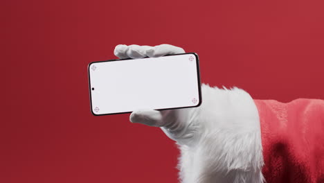 Video-Vom-Weihnachtsmann,-Der-Sein-Smartphone-Mit-Kopierplatz-Auf-Rotem-Hintergrund-Hält