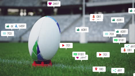 Animation-of-social-media-icons-foating-against-close-up-of-a-rugby-ball-on-a-stand-in-the-stadium