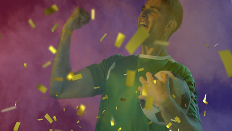 Animation-of-gold-confetti-over-cheering-caucasian-male-football-fan-in-green-shirt-holding-ball