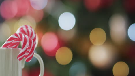 Video-Von-Einem-Weißen-Becher-Mit-Weihnachtsstöcken-Und-Weihnachtsbaumbeleuchtung-Mit-Kopierraum