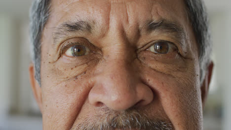 Video-close-up-portrait-of-senior-biracial-man-looking-to-camera-and-blinking-in-slow-motion