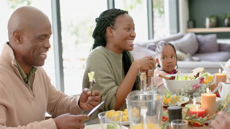 Portrait-of-african-american-parents-and-daughter-with-family-at-thanksgiving-dinner-,-slow-motion