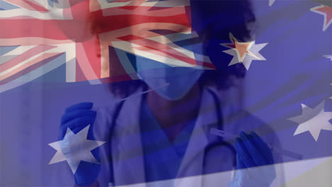 Animation-of-flag-of-australia-over-african-american-female-doctor-wearing-face-mask