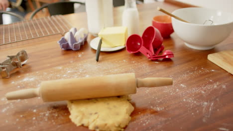 Baking-utensils-with-cookies-dough-lying-on-countertop-in-kitchen-at-home,-slow-motion