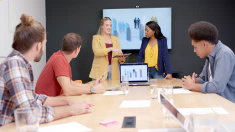 Happy-diverse-colleagues-in-discussion-at-presentation-in-meeting-room,-slow-motion