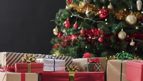 Video-of-christmas-tree-with-presents-and-fairy-lights-with-copy-space-on-black-background