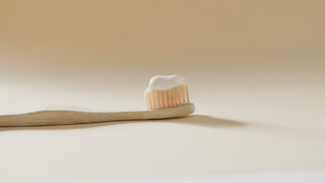 Close-up-of-toothbrush-with-toothpaste-on-beige-background