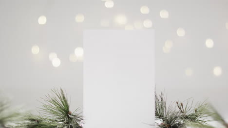 Video-of-christmas-decorations-and-white-card-with-copy-space-on-snow-background