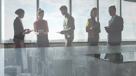 Composite-video-of-diverse-businesspeople-discussing-at-office-against-aerial-view-of-cityscape