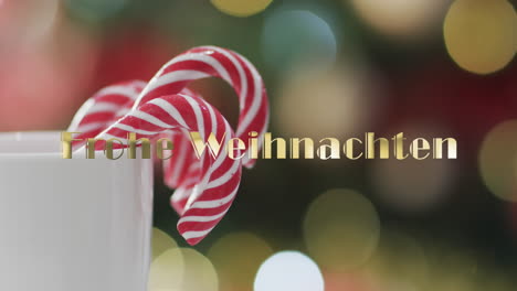Frohe-weihnachten-text-in-gold-over-candy-canes-and-bokeh-christmas-lights-in-background
