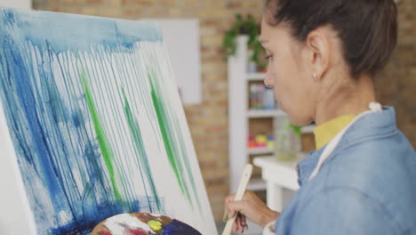 Biracial-woman-paints-on-canvas-at-home