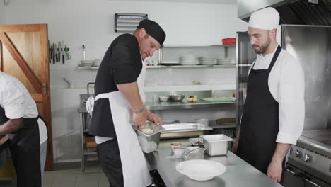 Three-diverse-male-chefs-preparing-meals-in-kitchen,-slow-motion