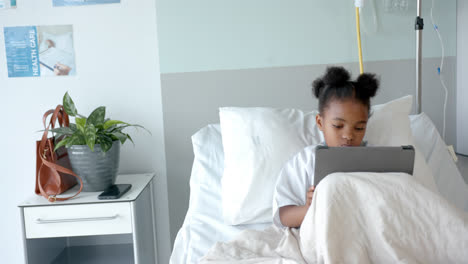 African-american-girl-using-tablet-in-hospital-bed-with-copy-space,-slow-motion