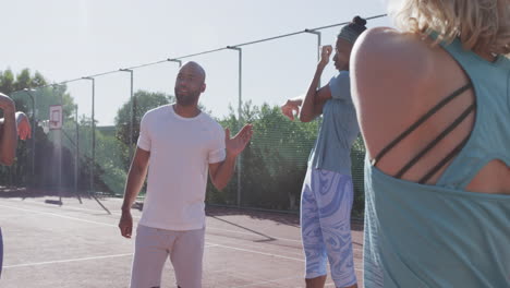 Biracial-man-discusses-strategy-on-an-outdoor-basketball-court