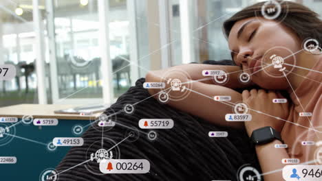 Animation-of-digital-and-social-media-icons-over-biracial-woman-taking-a-nap-on-the-couch-at-office