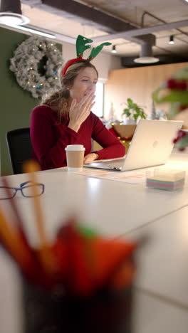 Vertical-video-of-happy-caucasian-casual-businesswoman-making-video-call-in-office,-slow-motion