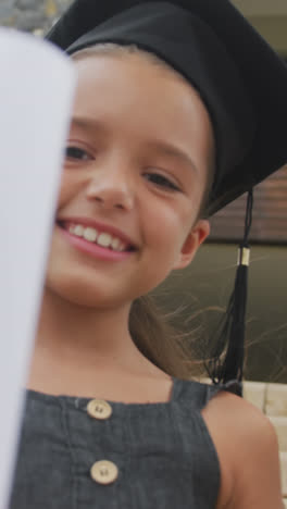 Video-of-happy-caucasian-girl-wearing-graduation-hat-and-holding-diploma