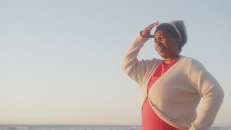 Glückliche-ältere-Afroamerikanische-Frau,-Die-Am-Strand-Spazieren-Geht,-In-Zeitlupe,-Mit-Kopierraum