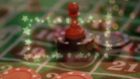 Animation-of-glowing-star-shaped-fairy-lights-against-red-dice-over-stack-of-casino-poker-chips