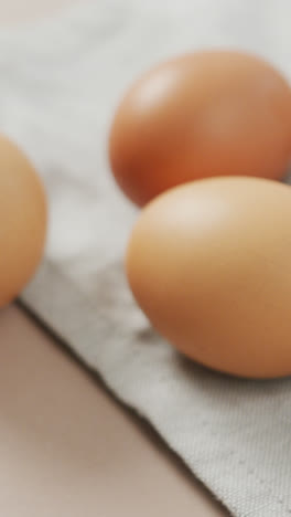 Video-of-close-up-of-eggs-and-on-rustic-cloth-on-beige-background
