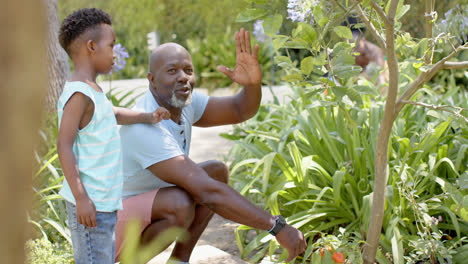 Feliz-Abuelo-Afroamericano-Con-Nieto-Trabajando-En-El-Jardín,-En-Cámara-Lenta