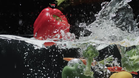 Video-of-vegetables-falling-into-water-with-copy-space-on-black-background
