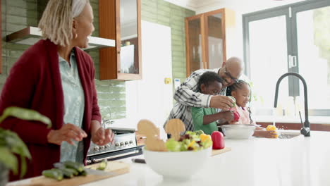 Glückliche-Afroamerikanische-Großeltern-Und-Enkelkinder-Beim-Gemüsewaschen-In-Der-Küche,-Zeitlupe