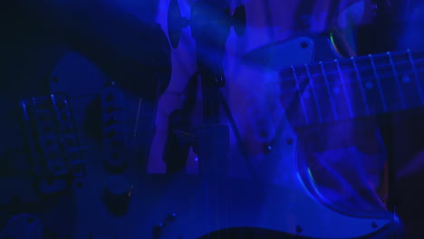 Animation-of-blue-shapes-over-musician-playing-guitar