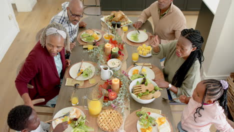 African-american-parents,-children-and-grandparents-celebrating-at-thanksgiving-dinner,-slow-motion