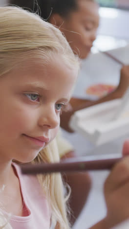 Video-of-focused-caucasian-girl-painting-during-art-lessons-at-school