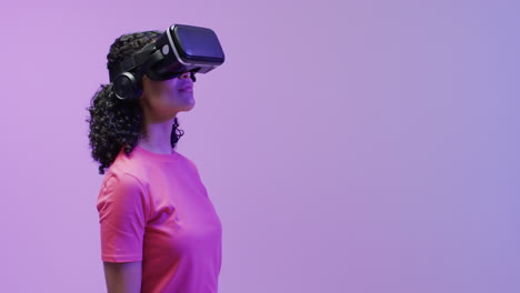 A-young-african-american-woman-is-immersed-in-a-virtual-reality-experience,-wearing-a-vr-headset