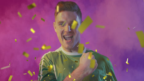 Animation-of-gold-confetti-over-cheering-caucasian-male-sports-fan-in-green-shirt