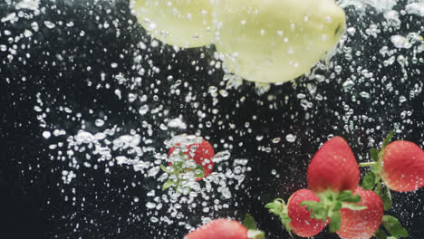 Video-of-apples-and-strawberries-falling-into-water-with-copy-space-on-black-background