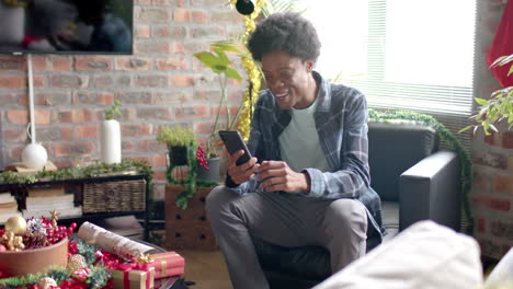 Happy-african-american-man-having-video-call-using-smartphone-at-home,-slow-motion