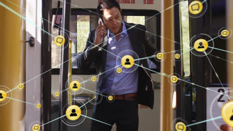 Animation-of-network-of-connections-with-icons-over-asian-businessman-talking-on-smartphone