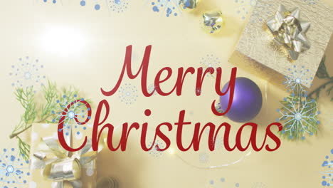 Animation-of-merry-christmas-text-and-snowflakes-floating-ove-christmas-decorations-and-gifts