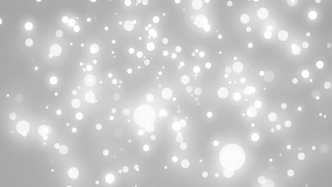 Glowing-white-christmas-light-particles-falling-on-grey-bokeh-background