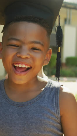 Video-Eines-Glücklichen-Afroamerikanischen-Jungen-Mit-Abschlusshut-Vor-Der-Schule