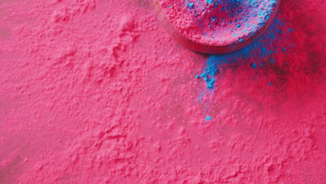 Video-of-pink-and-blue-coloured-powders-and-bowl-with-copy-space-on-black-background