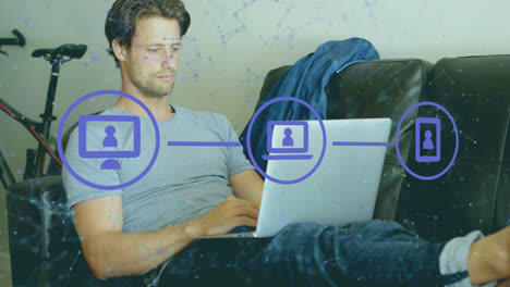 Animation-of-connected-icons-and-dots-over-caucasian-man-sitting-on-sofa-and-working-on-laptop