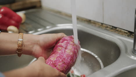 Hands-rinse-fresh-meat-under-tap-water-in-a-kitchen-sink