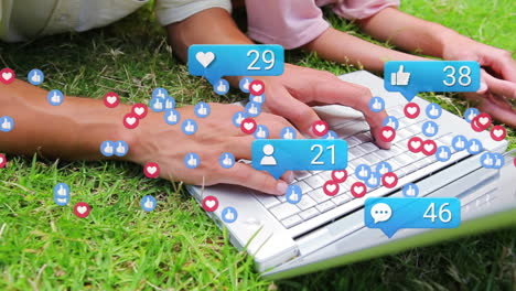 Animation-of-social-media-icons-over-mid-section-of-mother-and-daughter-using-laptop-in-the-garden