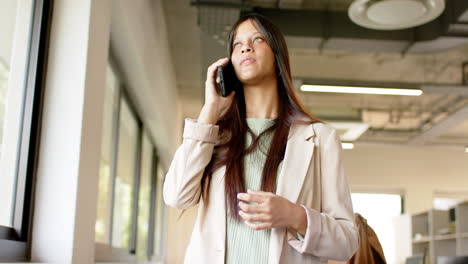 Happy-biracial-casual-businesswoman-talking-on-smartphone-in-office,-slow-motion