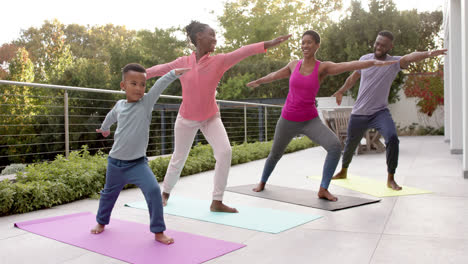 Happy-african-american-parents,-son-and-daughter-practicing-yoga-in-sunny-garden,-in-slow-motion