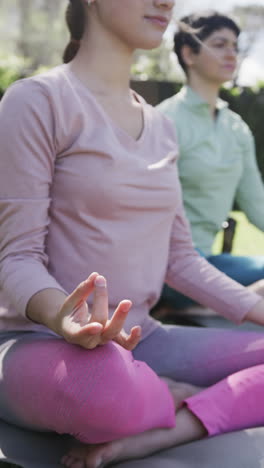 Happy-caucasian-lesbian-couple-practising-yoga-in-sunny-garden,-slow-motion