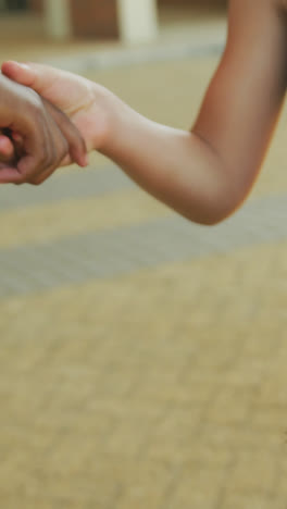 Video-of-hands-of-diverse-boys-congratulating-each-other-after-graduation-in-front-of-school