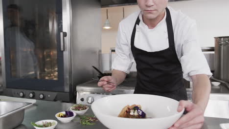 Caucasian-male-chef-decorating-meal-in-kitchen,-slow-motion