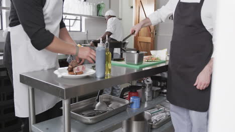 Three-diverse-male-chefs-preparing-meals-in-kitchen,-slow-motion