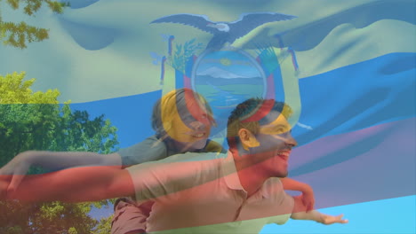 Composite-video-of-waving-ecuador-flag-against-caucasian-father-carrying-son-on-his-back-in-the-park