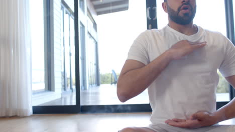 Biracial-Mann-Macht-Yoga-Und-Meditiert-Zu-Hause,-Zeitlupe,-Kopierraum